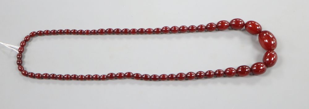 A single strand graduated simulated cherry amber oval bead necklace, 69cm, gross 54 grams.